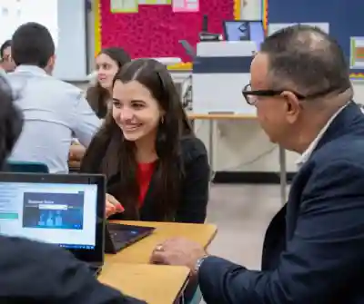 A confident high school female interacting with a JA volunteer.